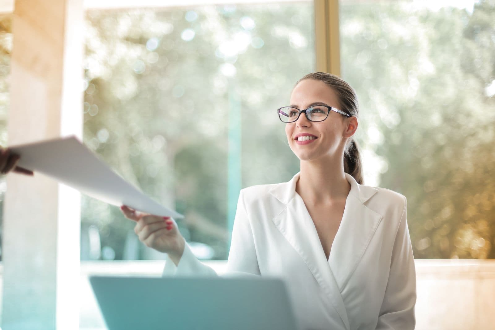 A professional handing a file to a colleague